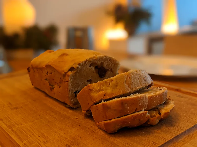 Easy banana bread sliced on a wooden board, showing the golden crust and moist crumb