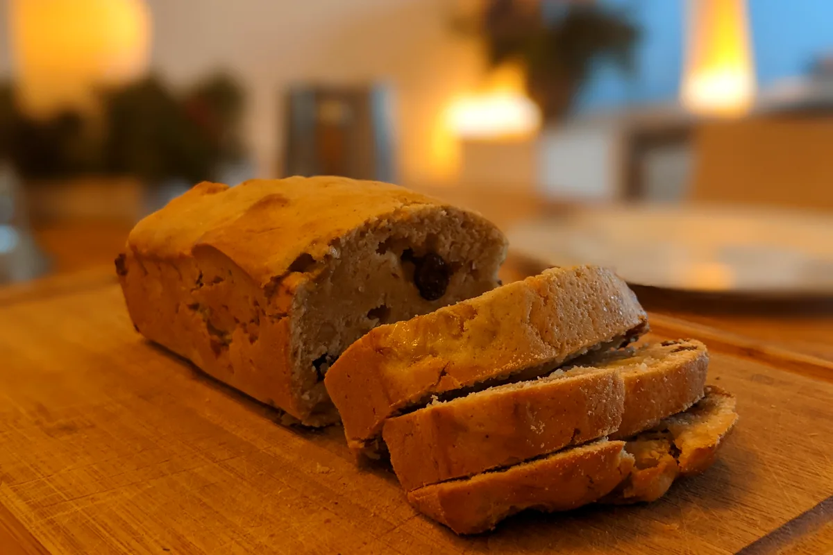 Easy banana bread sliced on a wooden board, showing the golden crust and moist crumb