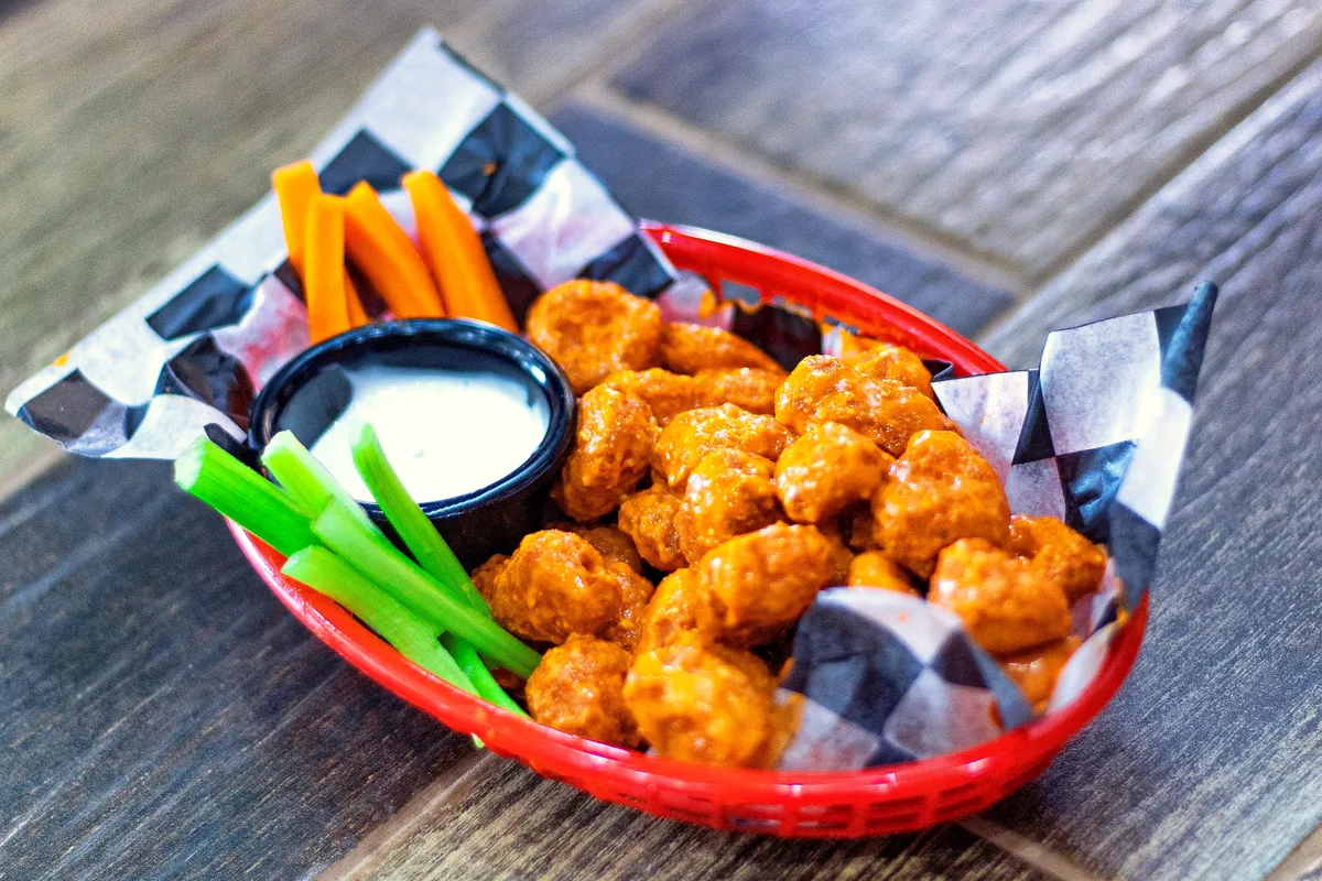 Easy baked buffalo cauliflower bites glazed in buffalo sauce with celery and ranch dip