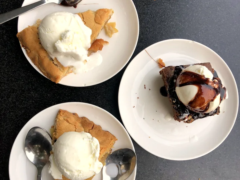 Slices of chocolate pie and cake served with vanilla ice cream and chocolate sauce