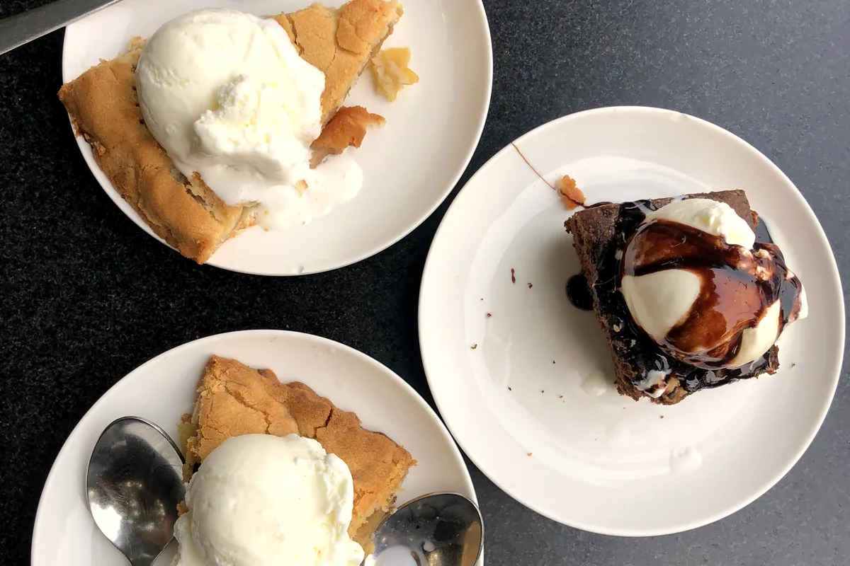 Slices of chocolate pie and cake served with vanilla ice cream and chocolate sauce