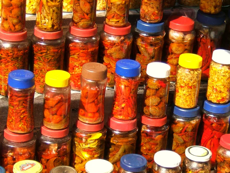 Jars of pickles in brine on a shop shelf, ready for preserving