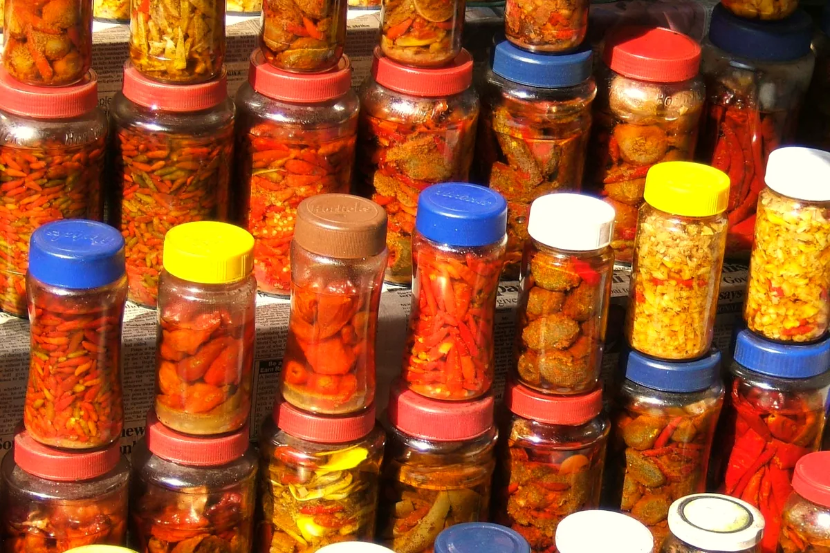 Jars of pickles in brine on a shop shelf, ready for preserving
