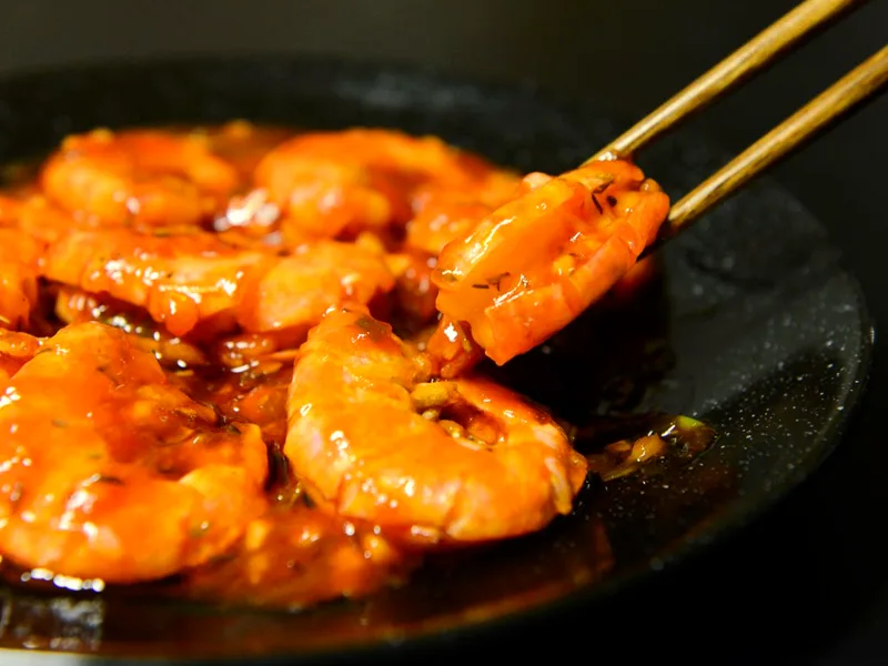 Air fryer garlic butter shrimp in a dish with lemon and fresh herbs