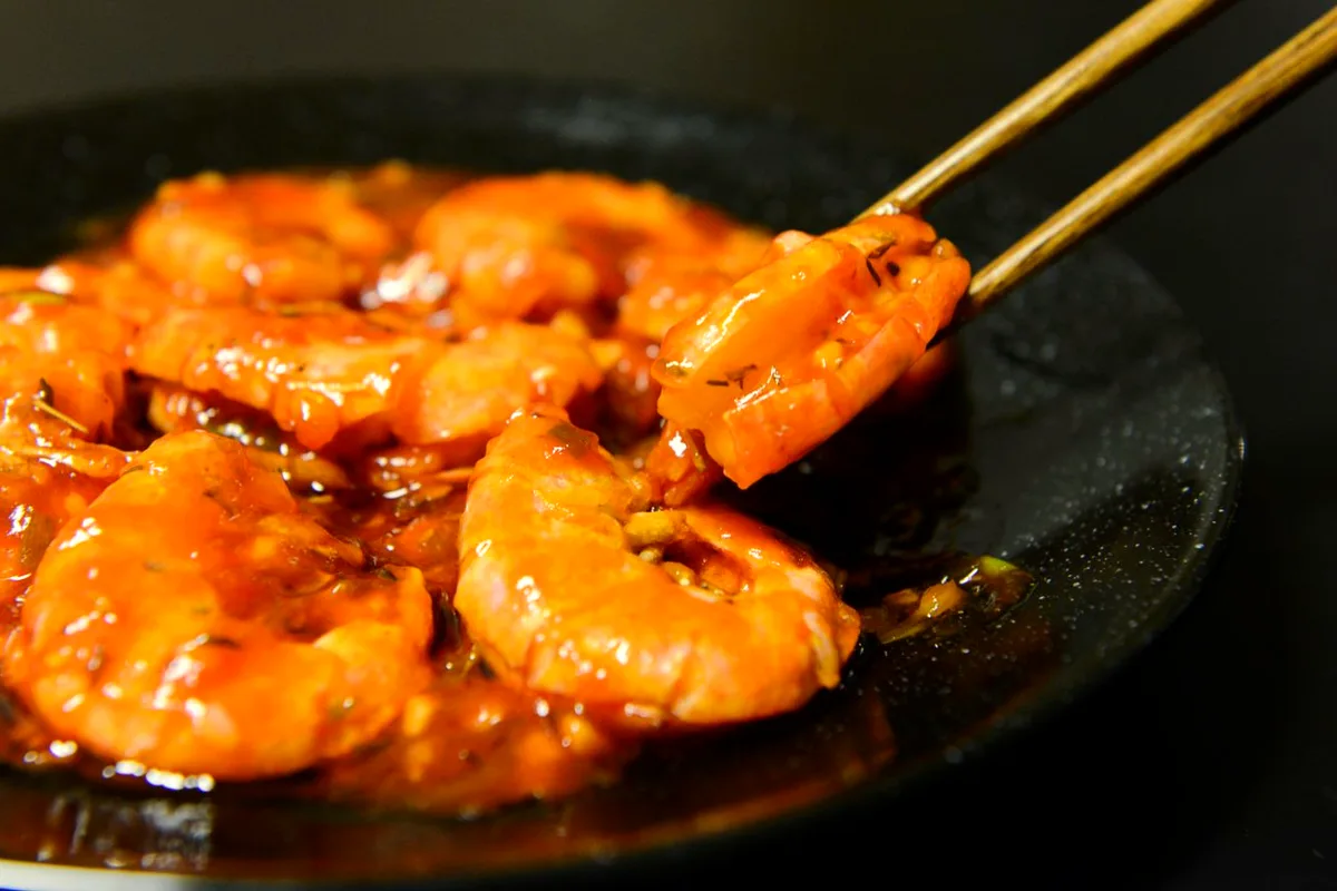 Air fryer garlic butter shrimp in a dish with lemon and fresh herbs