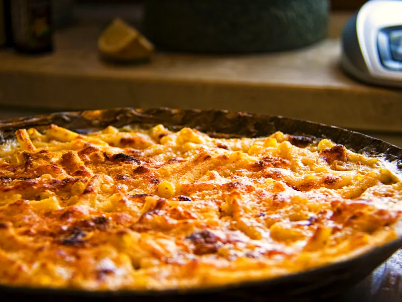 Easy baked mac and cheese in a round baking dish with a deep golden, crisp cheese top