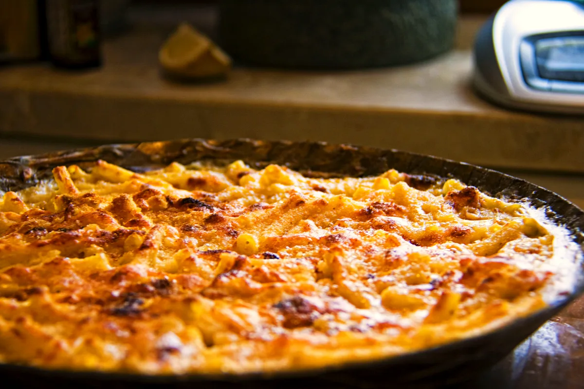 Easy baked mac and cheese in a round baking dish with a deep golden, crisp cheese top