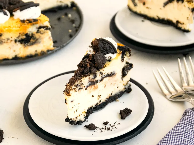 No-bake Oreo cheesecake bars with a dark cookie crust, white cookies and cream filling and crushed cookies on top