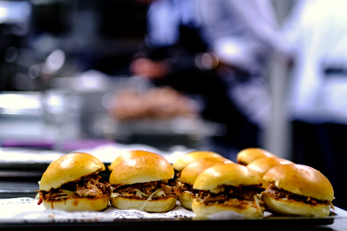 Tray of pulled pork sandwiches on soft buns filled with shredded slow-cooked pork
