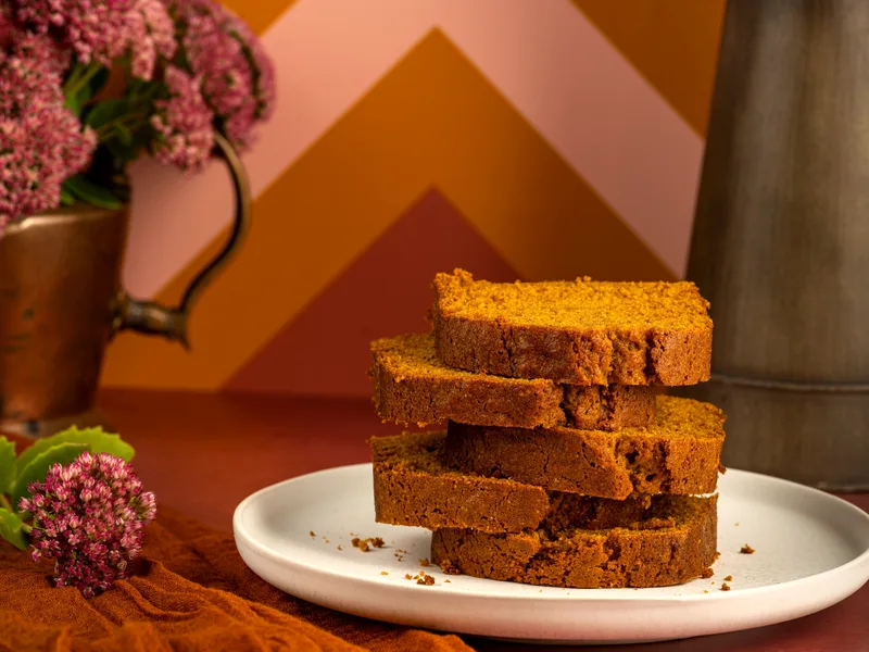 Easy chocolate chip pumpkin bread sliced on a board with chocolate chips melting in each slice
