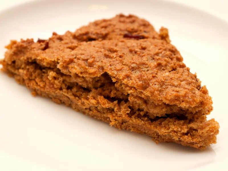 Pumpkin cranberry scone wedge on a white plate