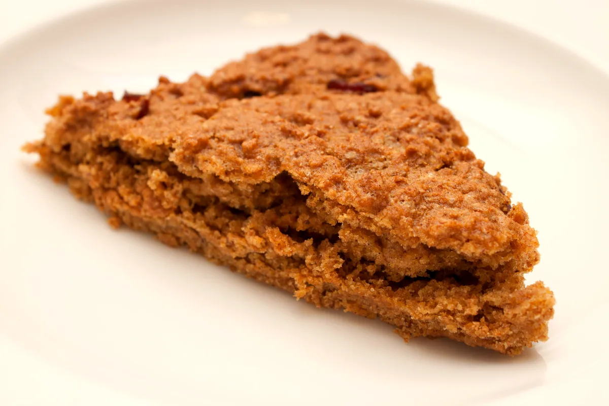 Pumpkin cranberry scone wedge on a white plate
