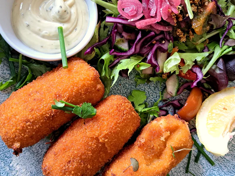 Crispy air fryer salmon patties served with salad and lemon wedges