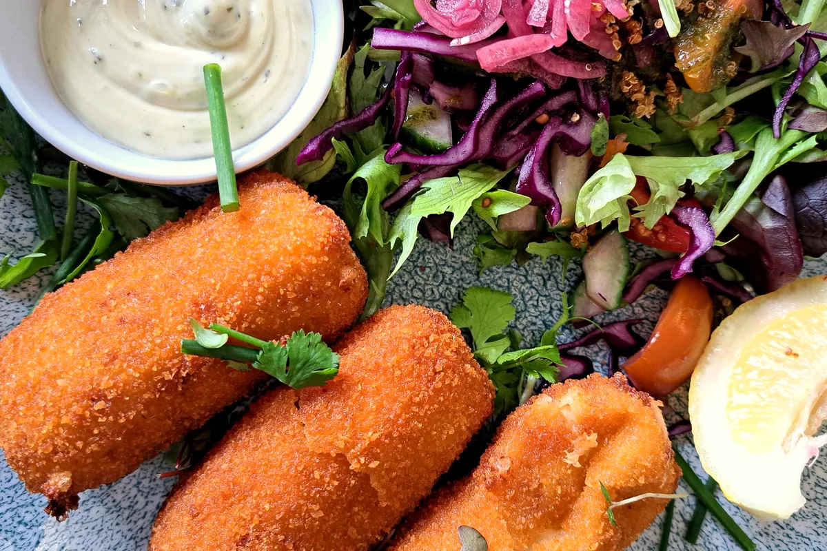 Crispy air fryer salmon patties served with salad and lemon wedges
