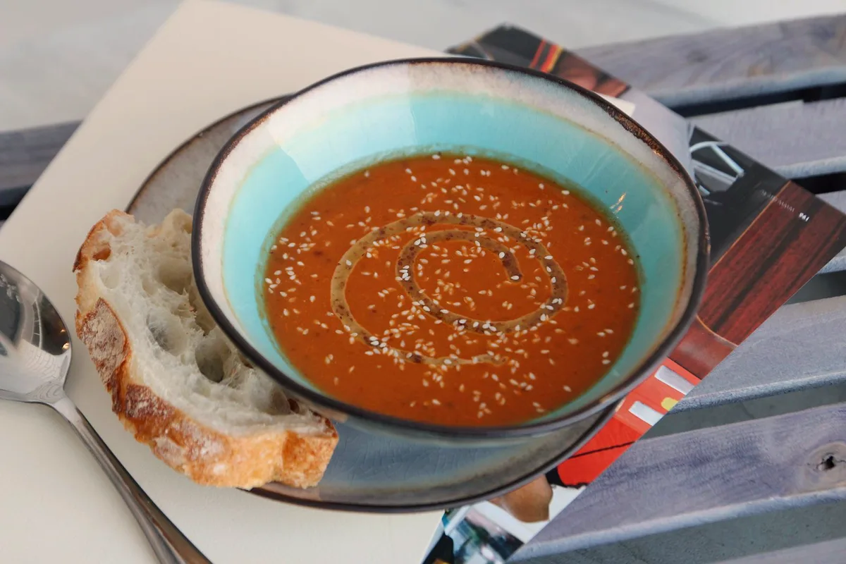 Creamy tomato tortellini soup in a bowl with spinach, basil and a swirl of cream